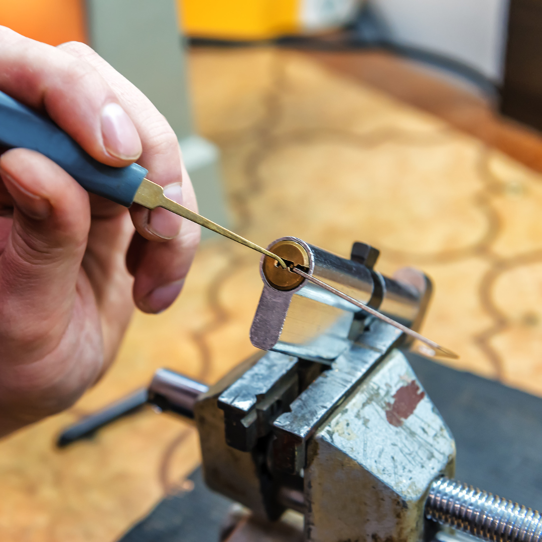 Cerradura desarmada sobre la puerta mientras el cerrajero realiza una reparación